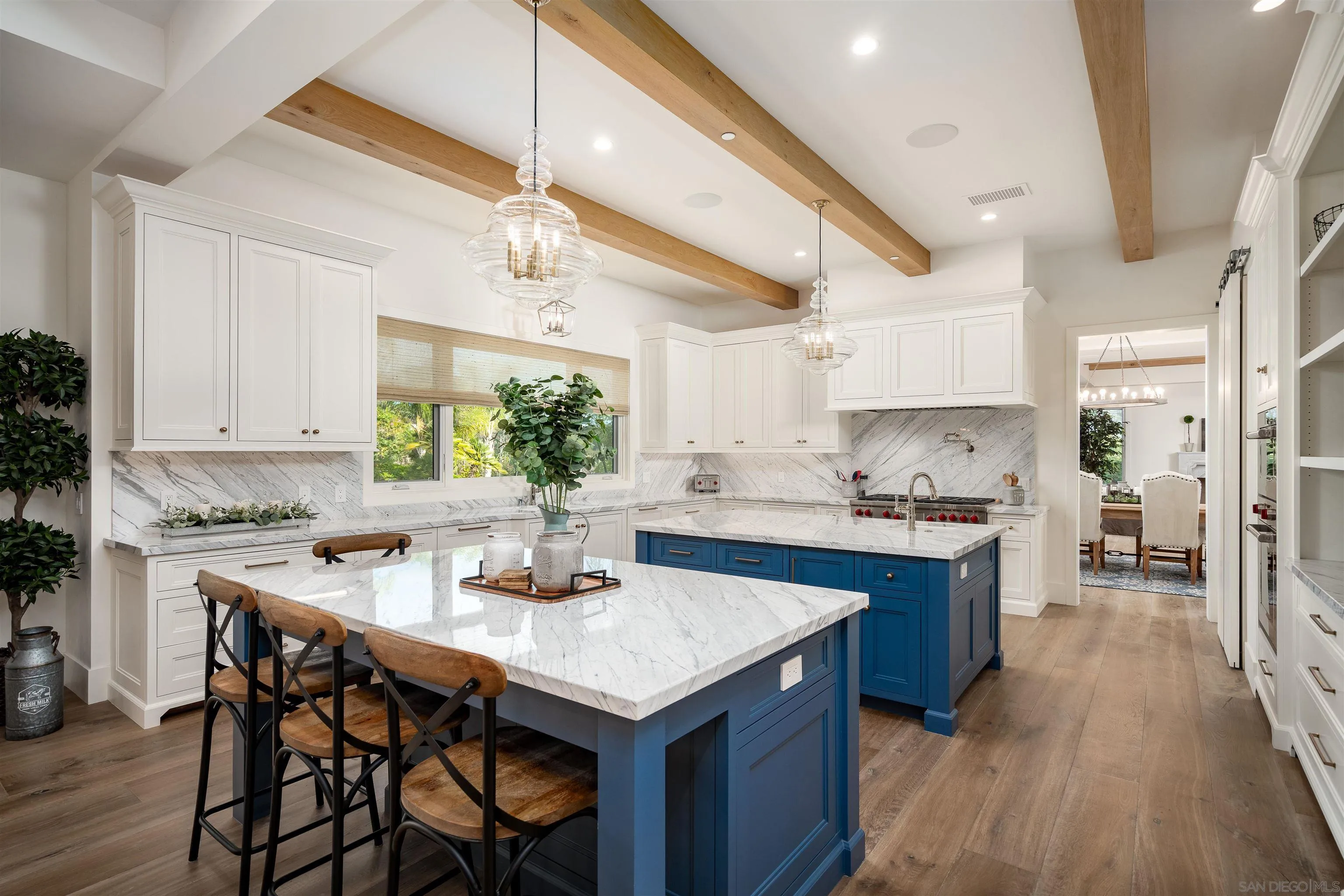 3419 Via Monteverde Encinitas, CA 92024 - Photo 17 of 73 a kitchen with granite countertop a table chairs stove a sink dishwasher and cabinets with wooden floor