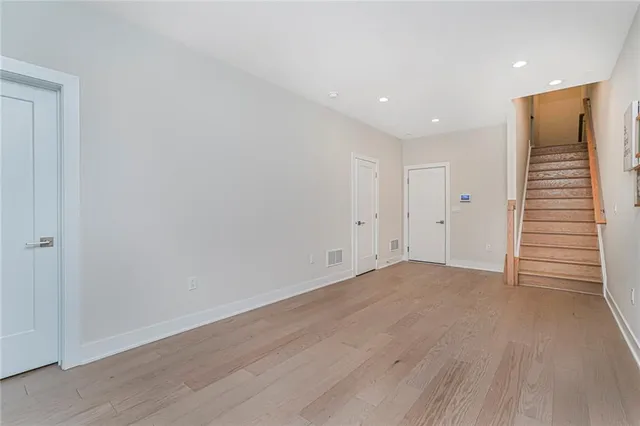a view of an empty room with wooden floor