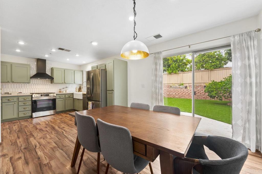 305 Cobblestone Place Santee, CA 92071 - Photo 8 of 41 a open kitchen with stainless steel appliances granite countertop a stove a refrigerator a kitchen island a table and chairs