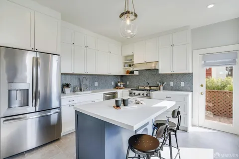 a kitchen with a sink a stove and chairs