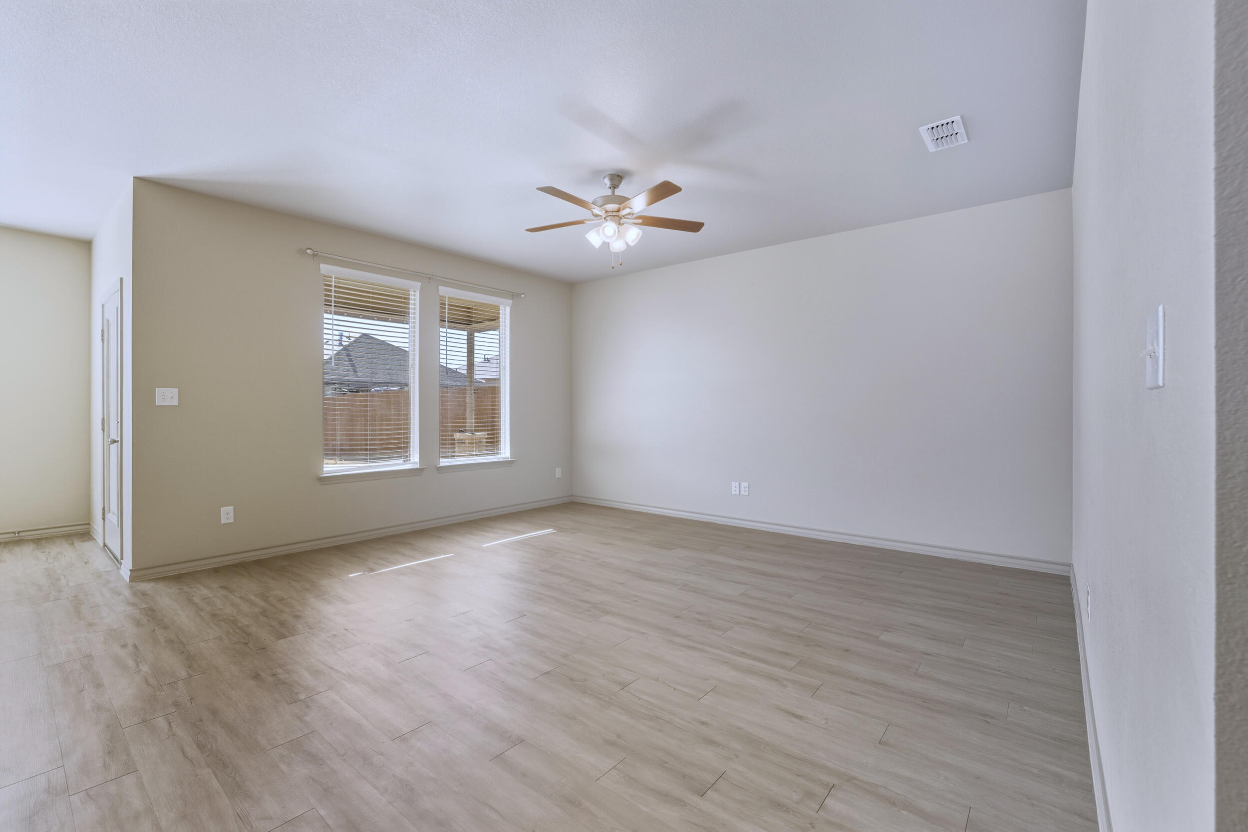 7103 22nd Street Lubbock, TX 79407 - Photo 12 of 30 a view of an empty room with a window and wooden floor