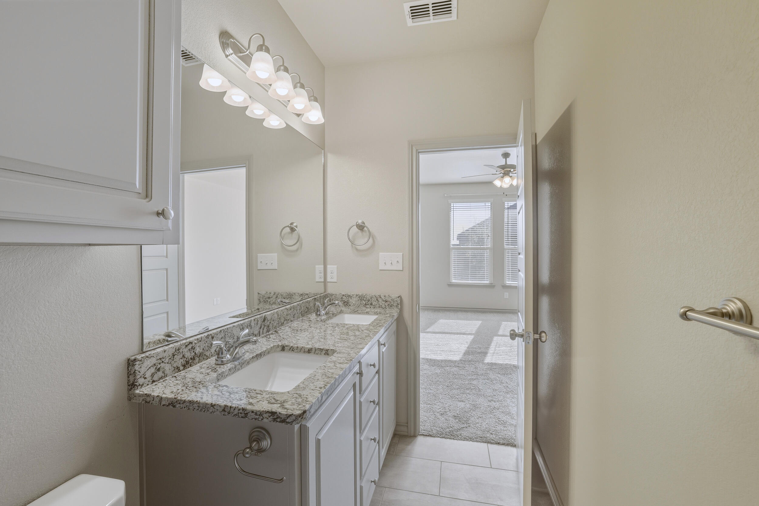 7103 22nd Street Lubbock, TX 79407 - Photo 15 of 30 a bathroom with a granite countertop sink a toilet and shower
