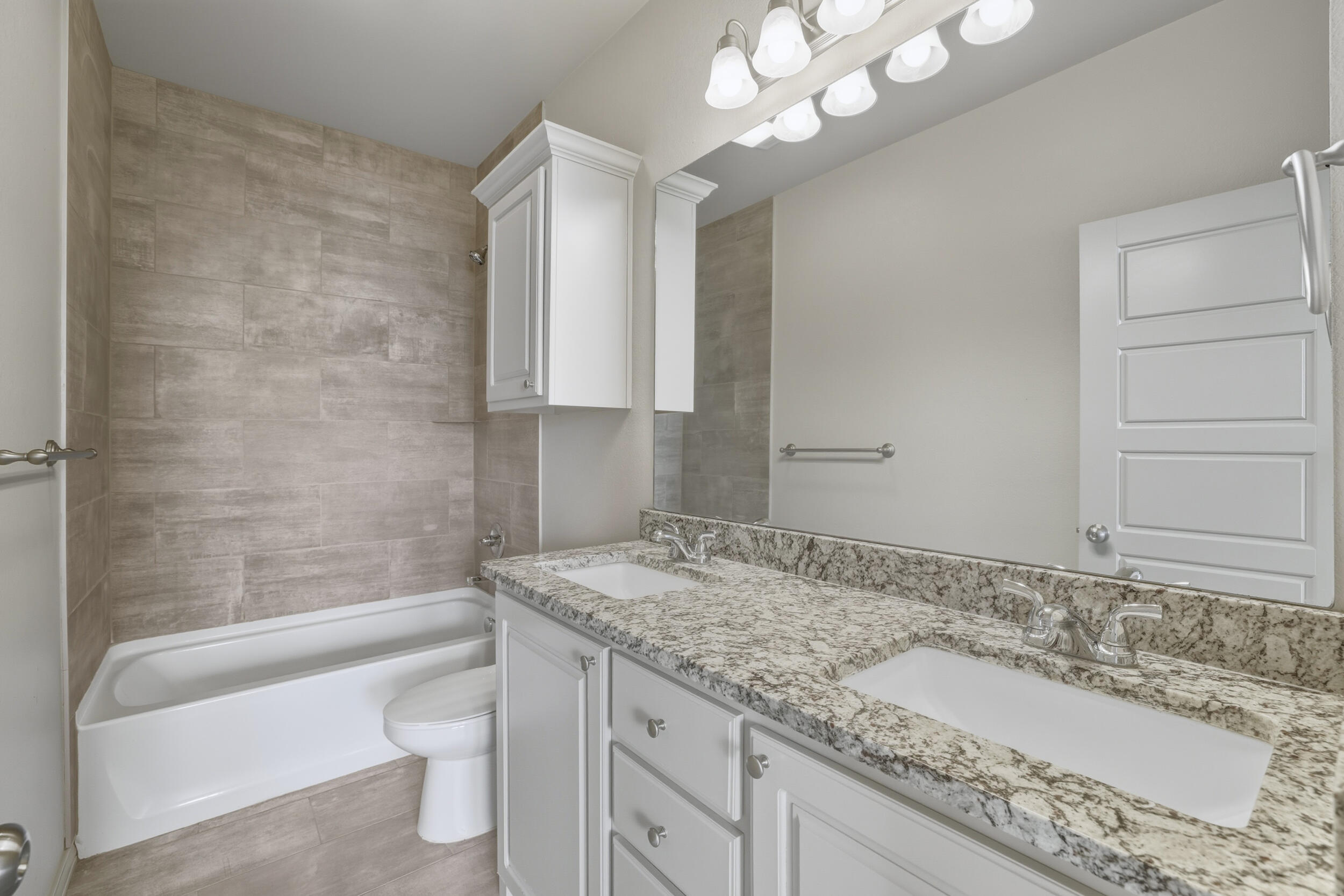 7103 22nd Street Lubbock, TX 79407 - Photo 16 of 30 a bathroom with a granite countertop sink a toilet and bathtub