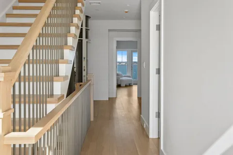 a view of a hallway with wooden floor and staircase