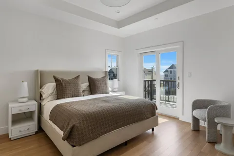 a bedroom with a bed and a chair with the wooden floor