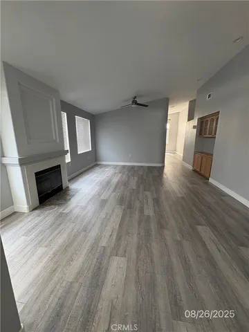 a view of empty room with wooden floor and fireplace