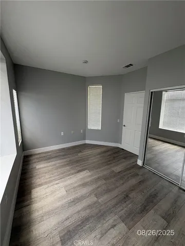 an empty room with wooden floor and mirror