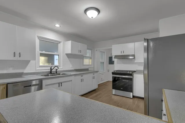 a kitchen with stainless steel appliances granite countertop a sink stove and refrigerator