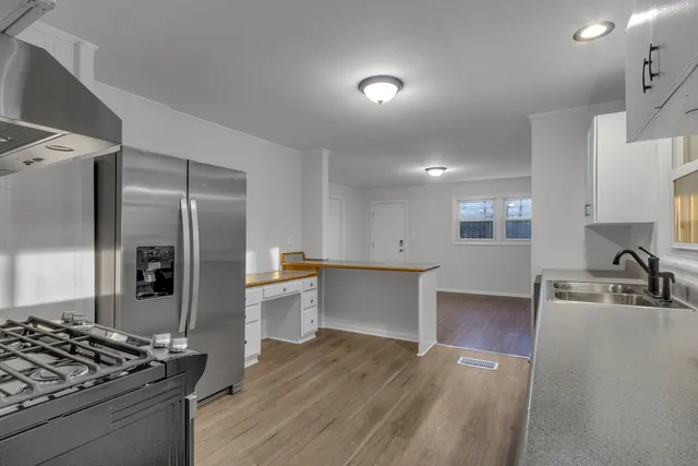 a kitchen with stainless steel appliances granite countertop a sink stove and refrigerator