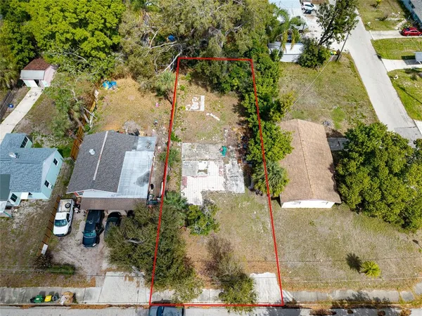 an aerial view of a house with a yard and large tree