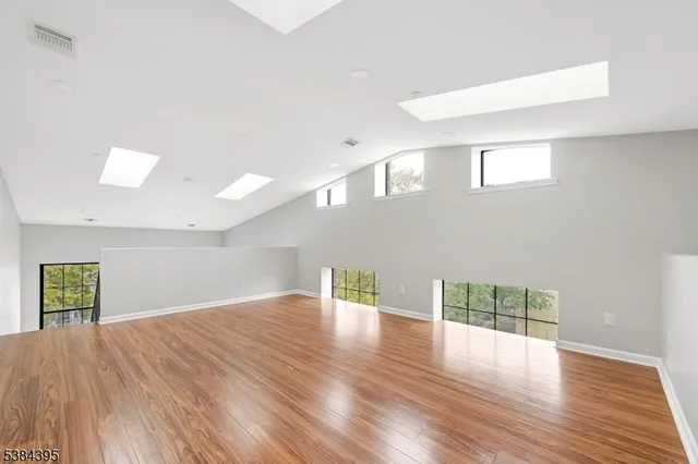 a view of empty room with wooden floor