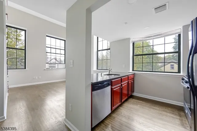 a large kitchen with stainless steel appliances granite countertop a stove and a large window