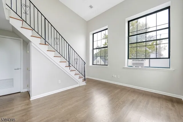 a view of room with wooden floor and windows