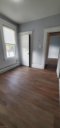 a view of room with wooden floor and windows