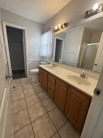 a spacious bathroom with a double vanity sink mirror and bathtub