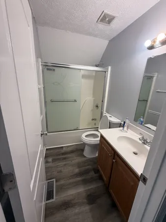 a bathroom with a sink and mirror with toilet