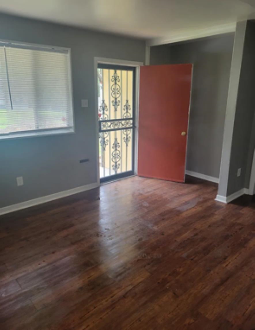 386 Elder Road Memphis, TN 38109 - Photo 4 of 12 an empty room with wooden floor and windows