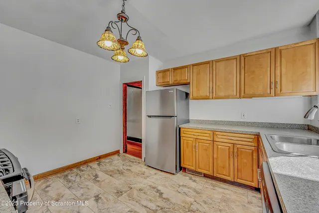 a kitchen with stainless steel appliances granite countertop a refrigerator and a stove top oven