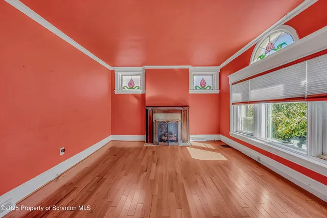 a view of an empty room with a fireplace and a window