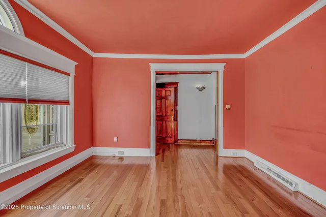 a view of a room with wooden floor and window