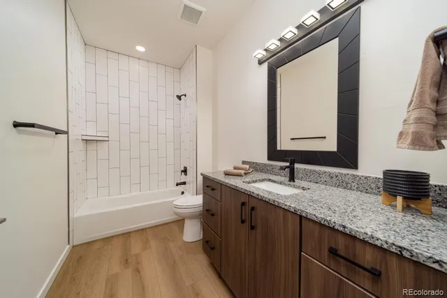 a bathroom with a granite countertop sink mirror and a bathtub