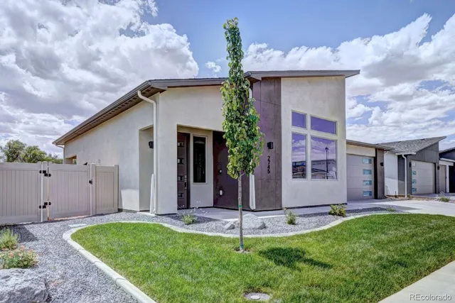a living room with lots of furniture wooden floor and kitchen view