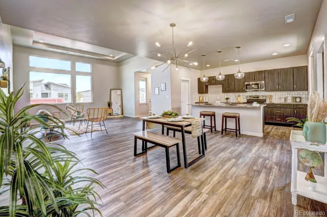 a view of a dining room with furniture a chandelier and wooden floor