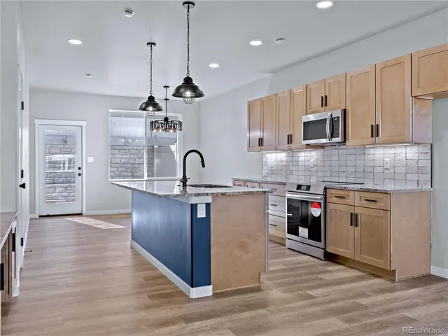 a kitchen with kitchen island a counter top a sink stainless steel appliances and cabinets