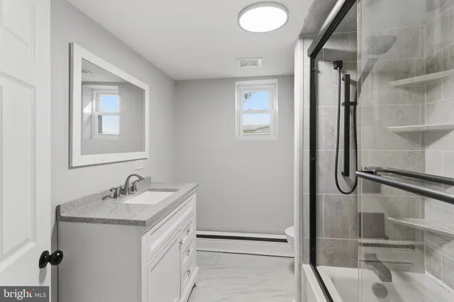 a bathroom with a double vanity sink mirror and shower
