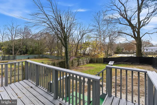 a view of deck and a yard with wooden fence