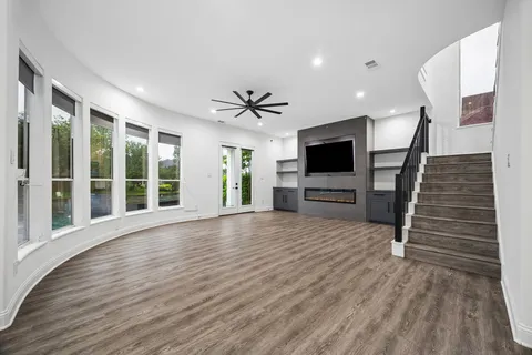 a view of a livingroom with wooden floor and a ceiling fan