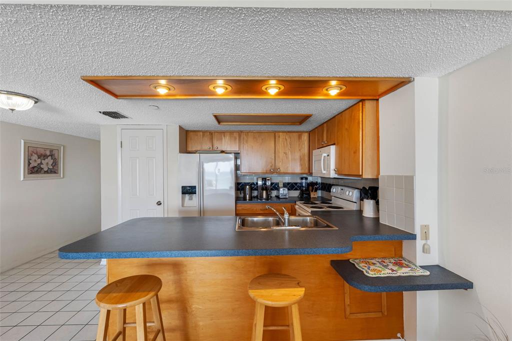 19440 Gulf Boulevard, Unit 506 Indian Rocks Beach, FL 33785 - Photo 53 of 67 a kitchen with dining table and chairs