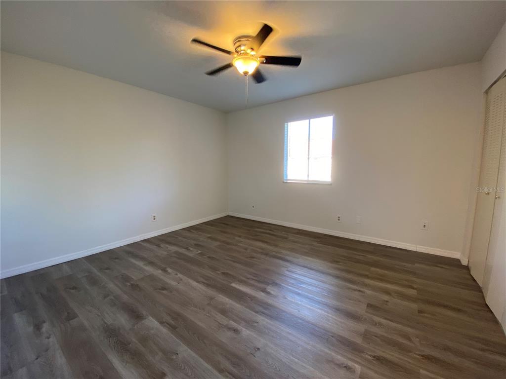 6519 West Newberry Road, Unit 1211 Gainesville, FL 32605 - Photo 8 of 10 an empty room with wooden floor and windows