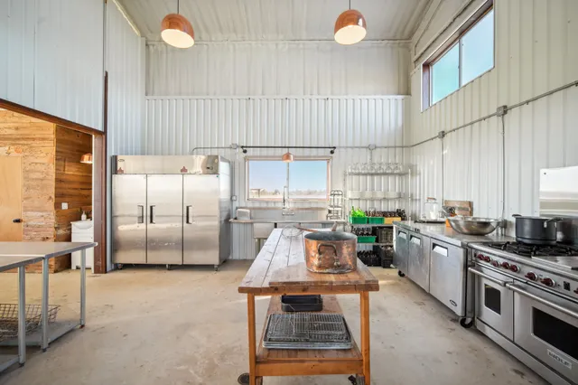 a kitchen with stainless steel appliances a white stove top oven cabinets and a window