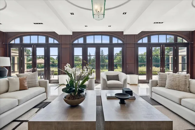 a bedroom with a bed and large windows