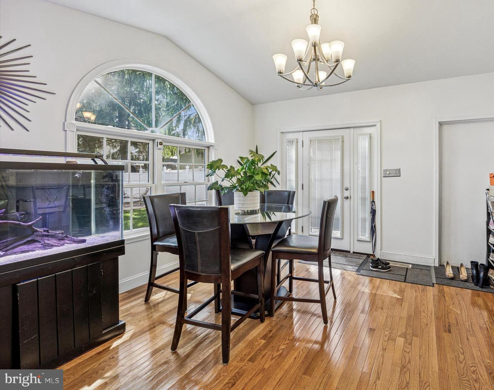 306 East Springfield Road Springfield, PA 19064 - Photo 16 of 40 a dining room with wooden floor a chandelier a wooden table and chairs