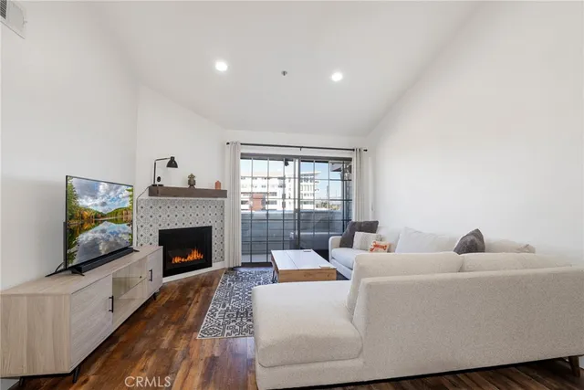 a living room with furniture and view of kitchen
