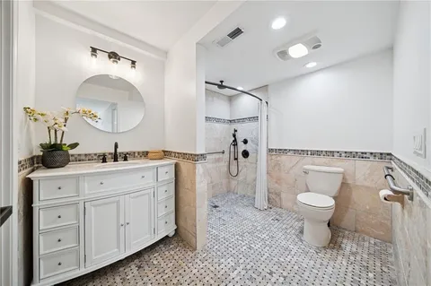 a spacious bathroom with a toilet a sink and a mirror