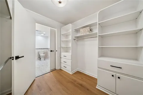 a view of empty room with cabinet and wooden floor