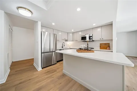 a kitchen with stainless steel appliances a refrigerator and a stove top oven