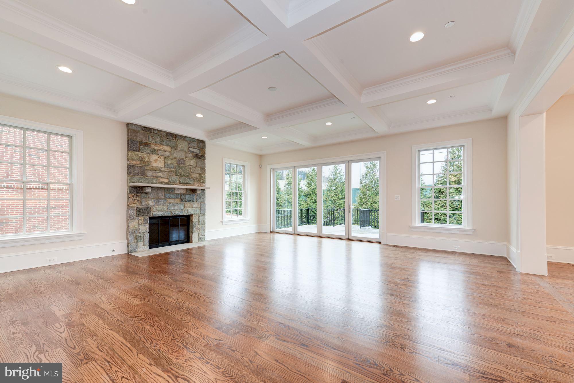 4513 Hoban Road Northwest Washington, DC 20007 - Photo 11 of 29 an empty room with wooden floor fireplace and windows
