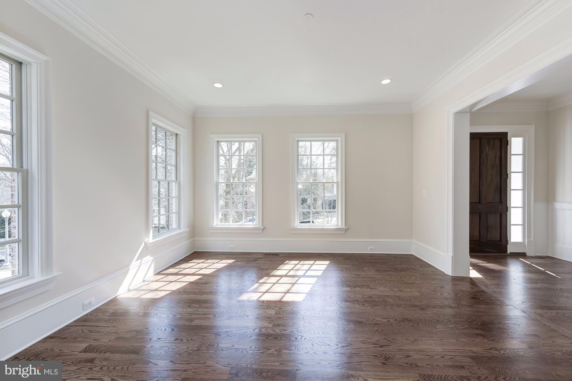 4513 Hoban Road Northwest Washington, DC 20007 - Photo 3 of 29 an empty room with wooden floor and windows with curtains view