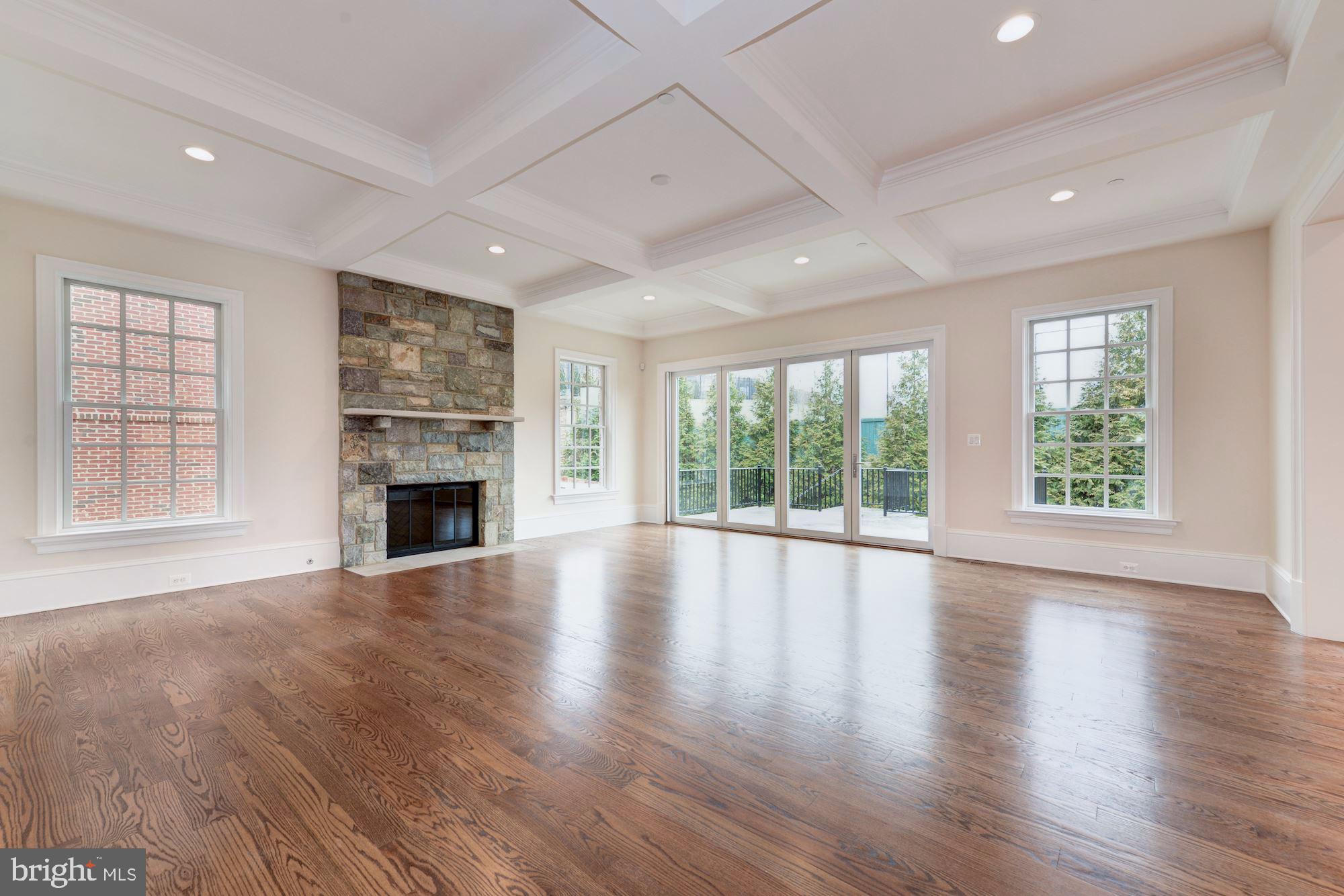 4513 Hoban Road Northwest Washington, DC 20007 - Photo 9 of 29 an empty room with windows fireplace and wooden floor