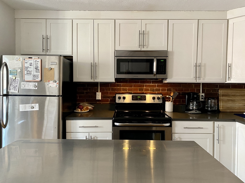 178 North Street, Unit 4 Boston, MA 02113 - Photo 3 of 8 a kitchen with stainless steel appliances a refrigerator a stove a microwave and cabinets
