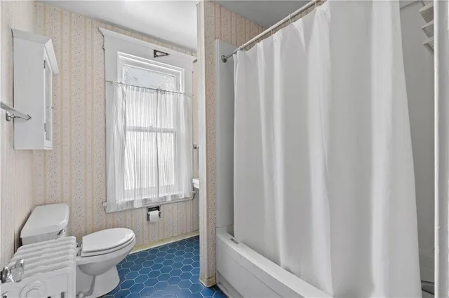 a bathroom with a toilet and a shower