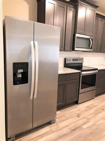 a kitchen with stainless steel appliances granite countertop a refrigerator and a microwave