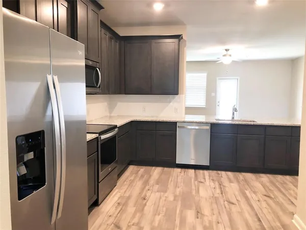 a kitchen with stainless steel appliances kitchen island granite countertop a refrigerator a sink and dishwasher
