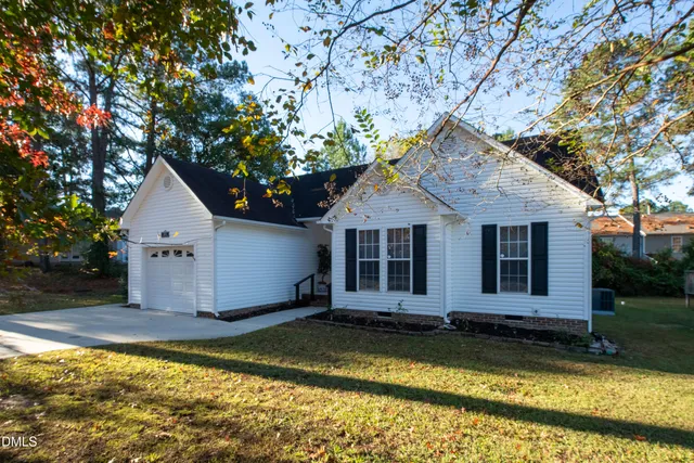 a view of a house with a yard and large tree