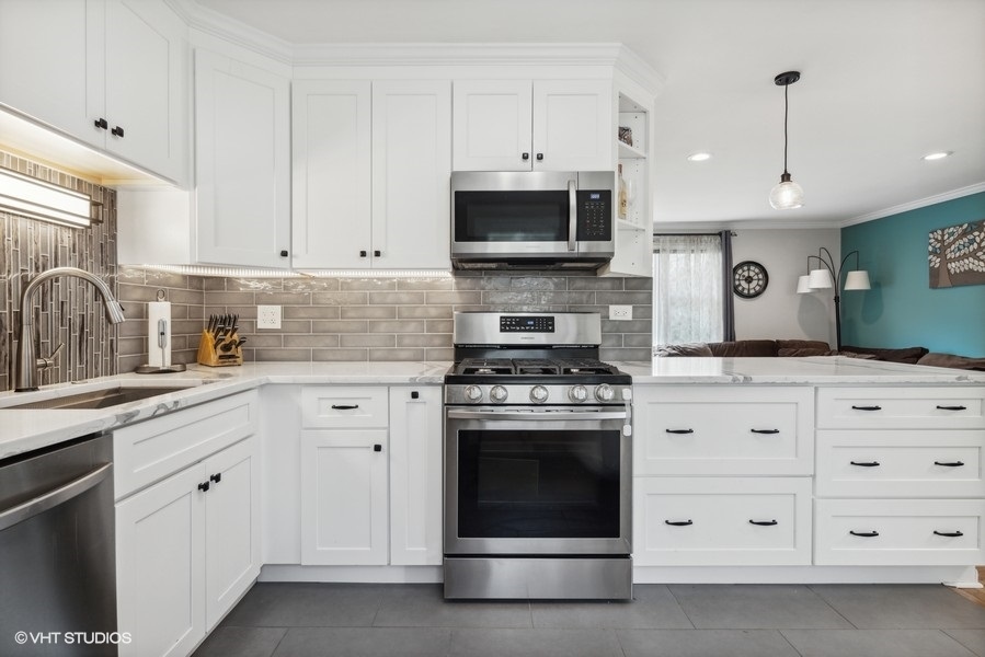 534 71st Street Darien, IL 60561 - Photo 10 of 20 a kitchen with stainless steel appliances granite countertop a stove a sink and a microwave