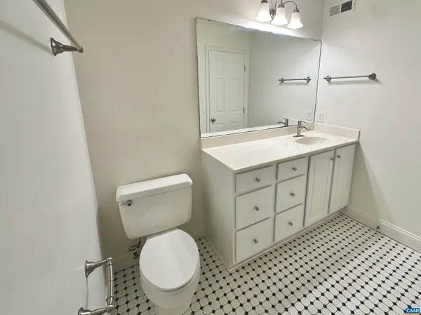 a bathroom with a granite countertop toilet sink and mirror